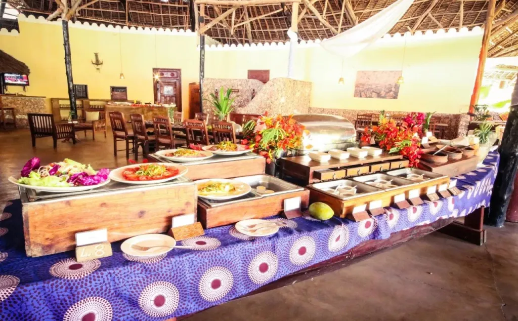 Un buffet propose une variété de plats colorés dans une salle à manger lumineuse.