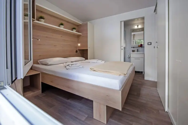 Une chambre lumineuse avec un grand lit et un accès à une salle de bain.