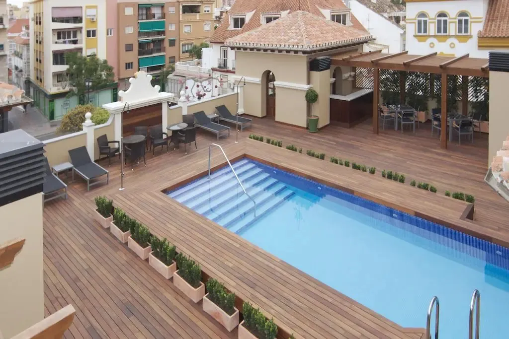 Terrasse avec piscine et mobilier de détente.