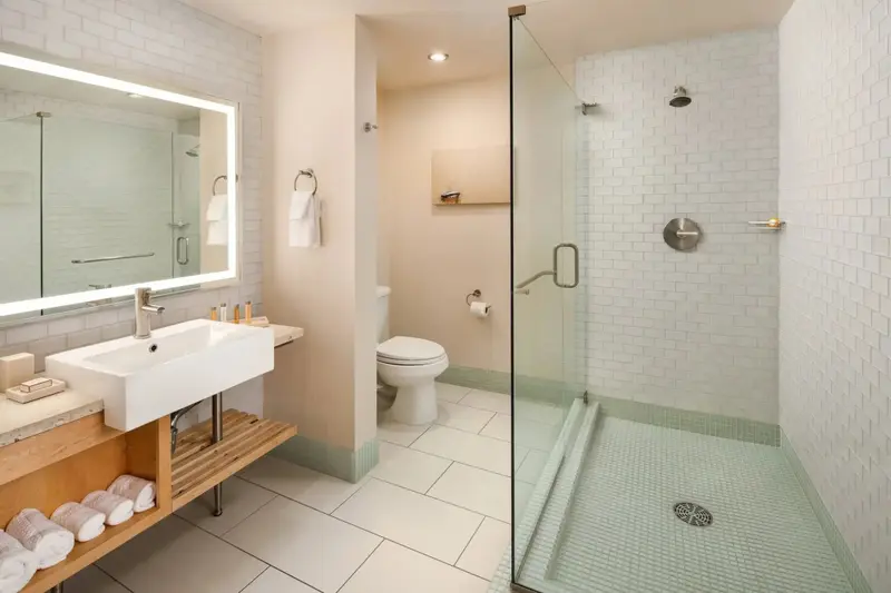 Une salle de bain moderne avec douche à l'italienne et vasque sur meuble.