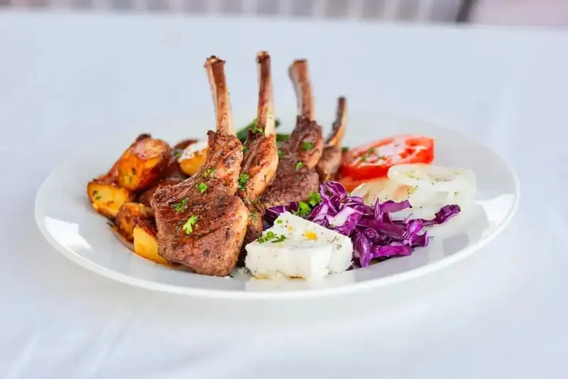 Assiette de viande grillée accompagnée de pommes de terre et de légumes.