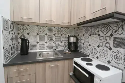Une kitchenette moderne avec des armoires claires et un carrelage décoratif.