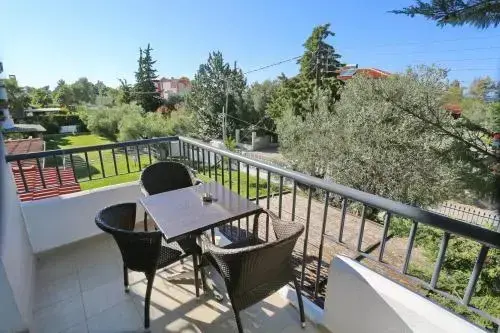 Une terrasse aménagée avec une table et des chaises offre une vue sur la végétation environnante.