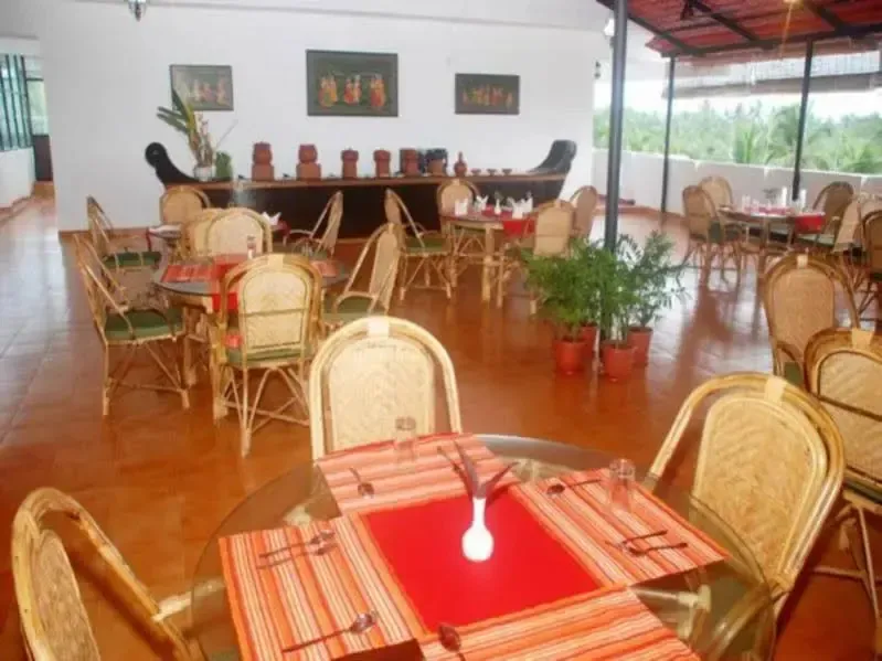 Une salle à manger lumineuse avec des tables dressées et des chaises en rotin.