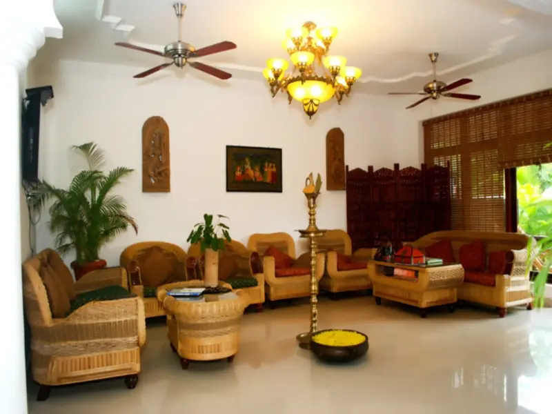 Espace de détente intérieur avec mobilier en rotin et décoration murale.