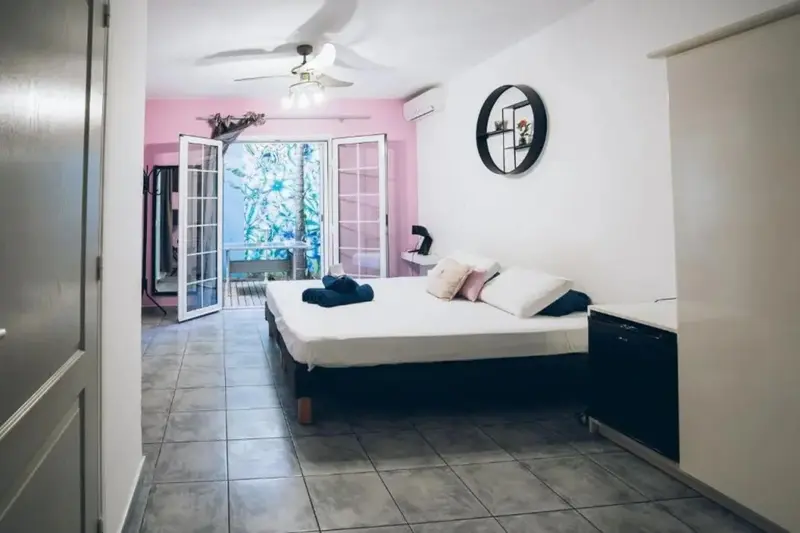 Une chambre lumineuse avec un grand lit et un accès à une terrasse.