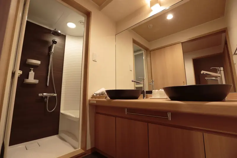 Une salle de bain moderne avec une douche à l'italienne et deux vasques.