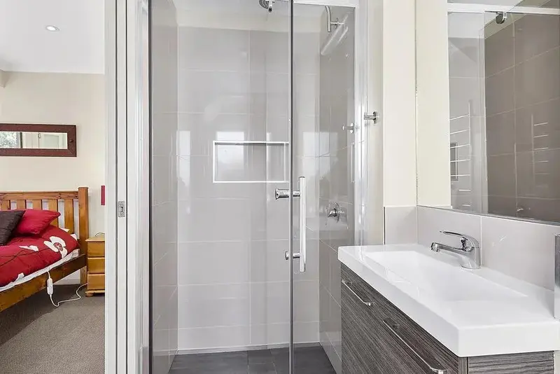 Une salle de bain moderne avec douche à l'italienne et vasque.