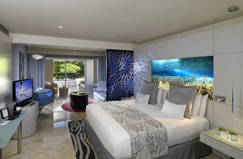 Une chambre lumineuse avec un grand lit et un accès à une terrasse.