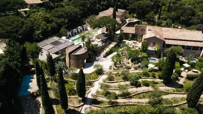 Vue aérienne d'un ensemble immobilier avec piscine et végétation luxuriante.