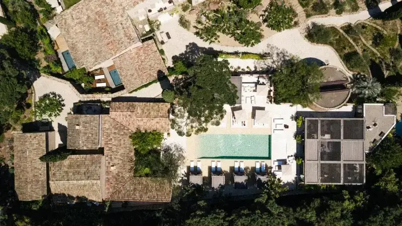 Vue aérienne d'une propriété avec piscine et bâtiments aux toits en tuiles.