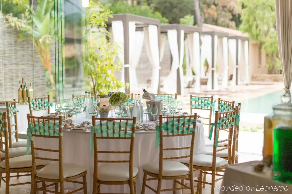 Une table de réception est dressée dans une salle lumineuse avec vue sur une piscine.