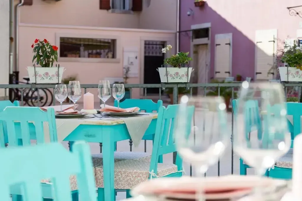 Tables dressées en terrasse avec des verres et de la vaisselle.