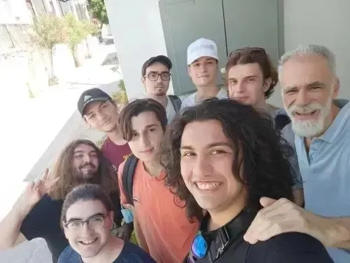 Groupe de personnes souriantes posant pour une photo en extérieur.