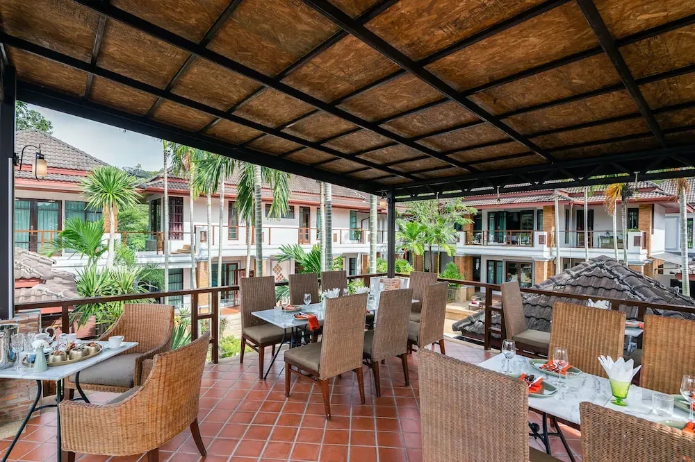 Une terrasse couverte abrite des tables et des chaises pour les repas.
