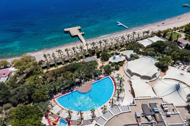 Vue aérienne d'un complexe hôtelier avec piscine et plage.