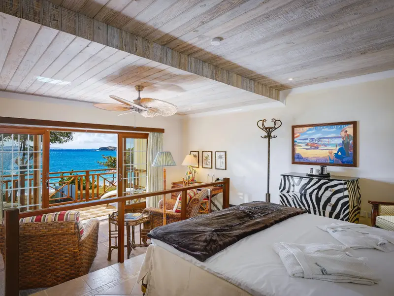 Une chambre lumineuse avec un grand lit donnant sur une vue mer.