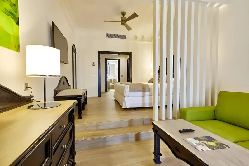 Une chambre lumineuse avec un coin salon et un lit.