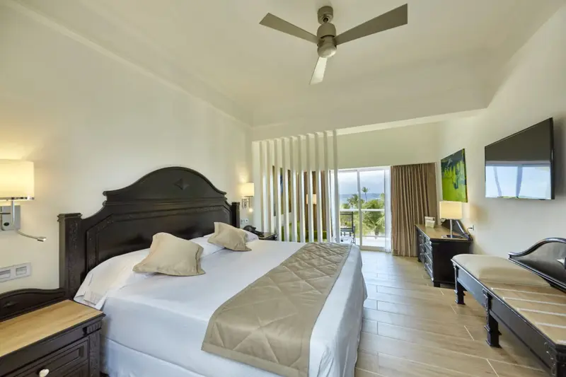Une chambre lumineuse avec un grand lit et un accès à une terrasse.
