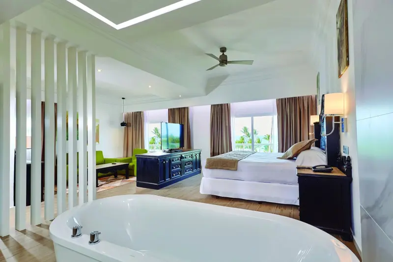 Une chambre spacieuse avec un lit king-size et une baignoire sur pied.