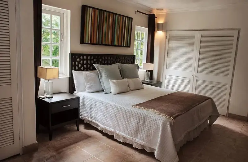 Une chambre lumineuse avec un grand lit et une décoration sobre.