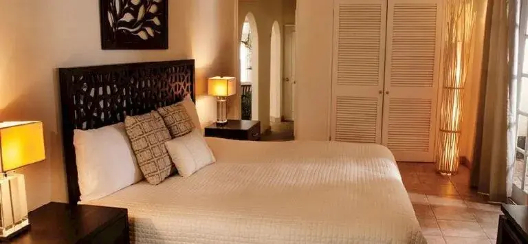 Une chambre lumineuse avec un grand lit et une décoration soignée.