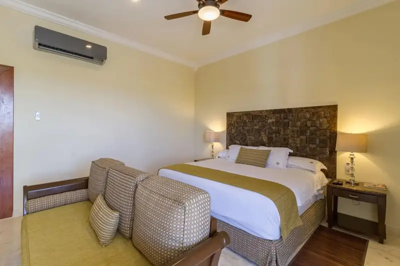 Une chambre lumineuse avec un grand lit et un coin salon.