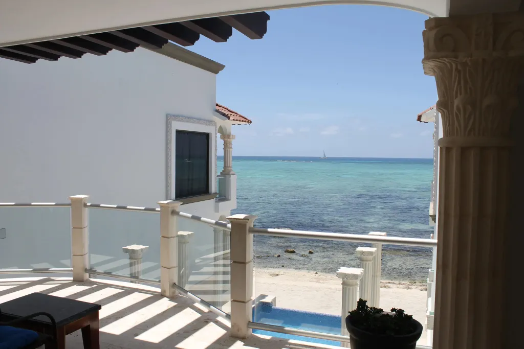 Vue sur la mer depuis une terrasse ombragée.