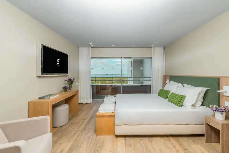 Une chambre lumineuse avec un grand lit et une vue sur la mer.