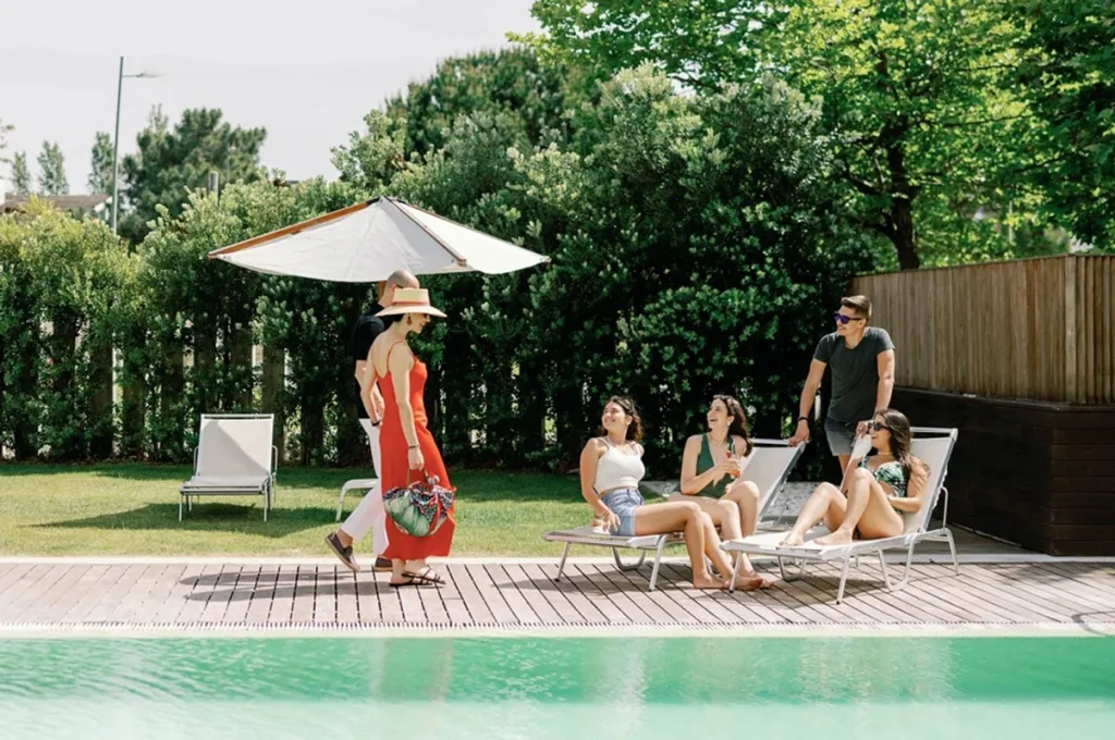 Des personnes se détendent au bord d'une piscine ensoleillée.