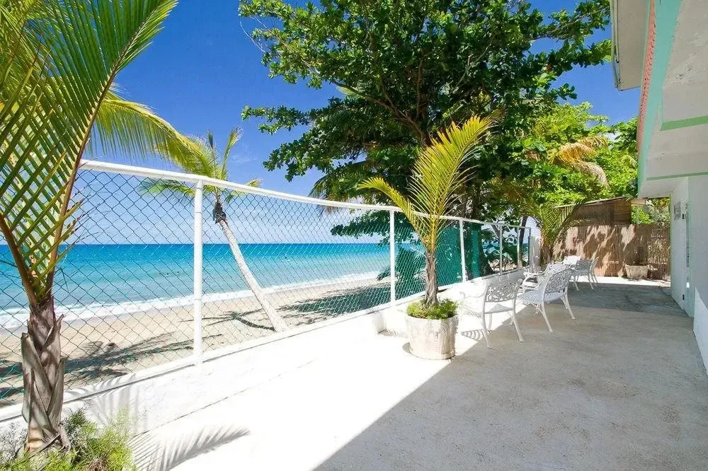 Terrasse ensoleillée avec vue sur la mer et la plage.