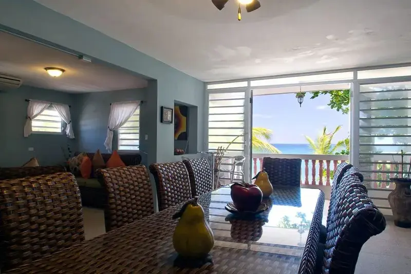 Une salle à manger lumineuse s'ouvre sur une vue sur la mer.