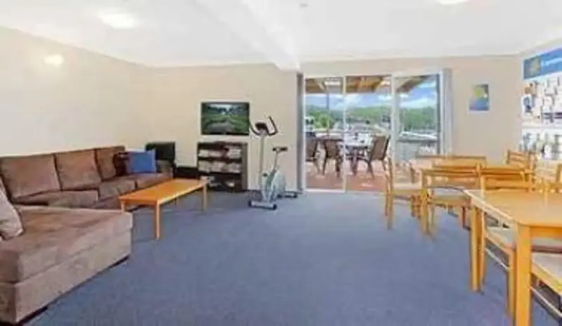 Espace de détente avec canapés et table à manger près d'une baie vitrée.