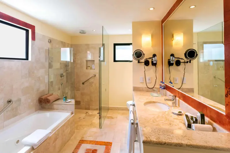 Une salle de bain lumineuse avec baignoire et double vasque.