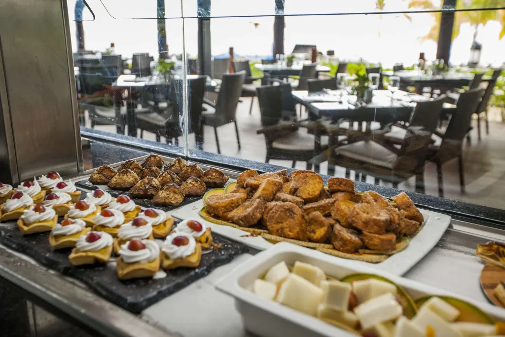 Un buffet propose une variété de pâtisseries et de fruits frais.