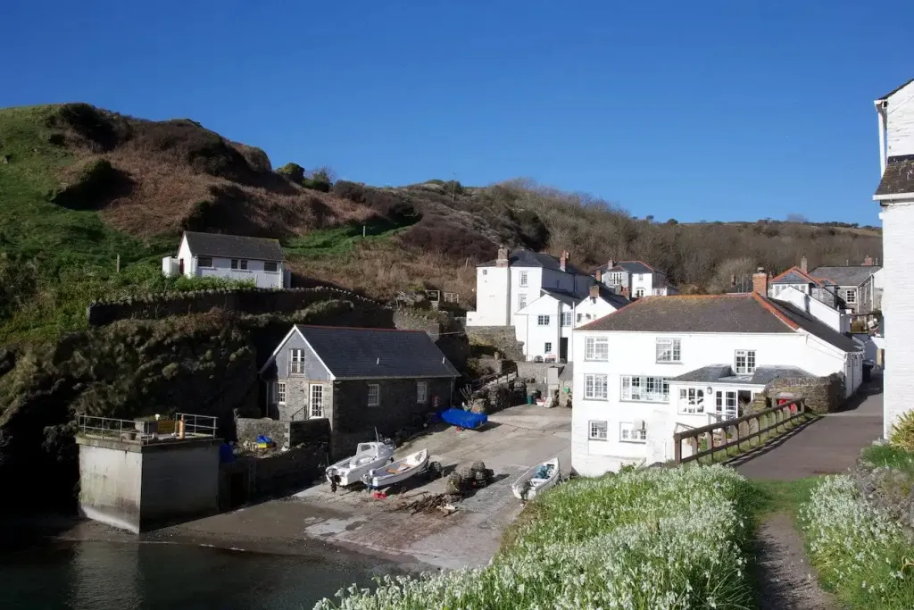Petites maisons blanches regroupées au bord de l'eau, avec des bateaux amarrés.