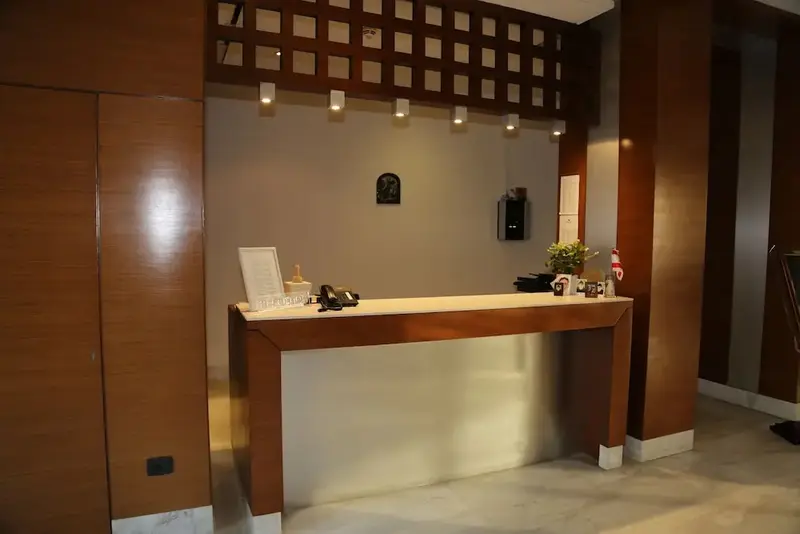 Un comptoir d'accueil en bois clair dans un hall d'hôtel.