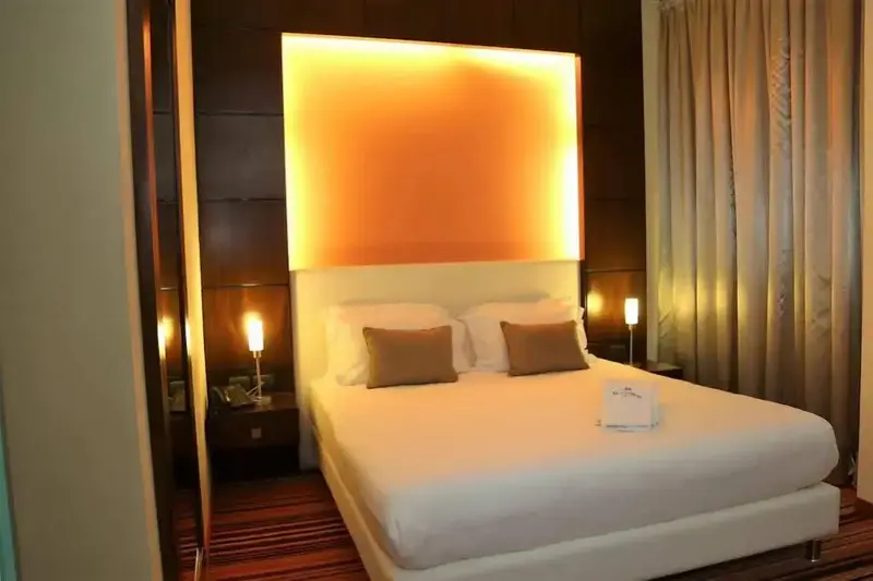 Une chambre lumineuse avec un grand lit et des coussins décoratifs.