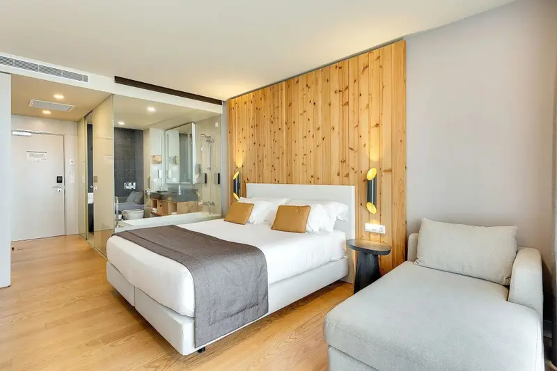 Une chambre lumineuse avec un grand lit et un coin salon.