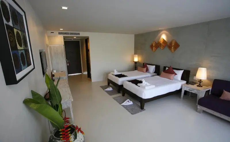 Une chambre lumineuse avec deux lits simples et une décoration murale.