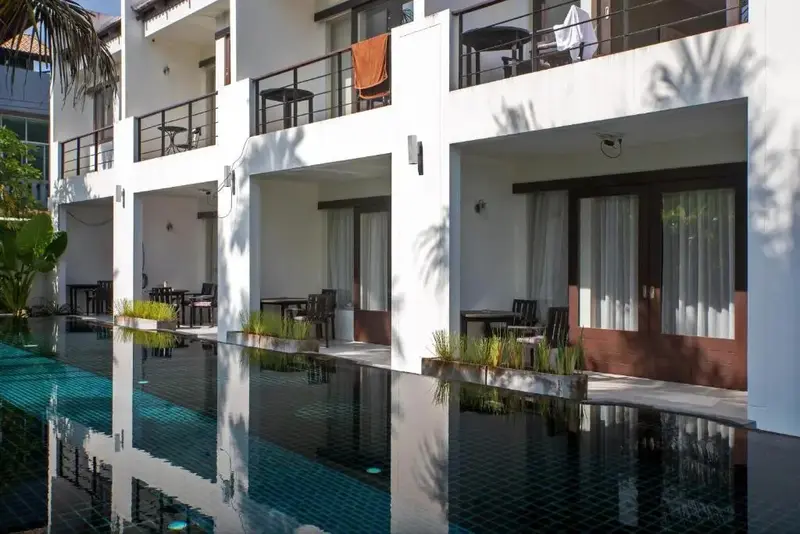 Terrasse avec mobilier devant des logements blancs.