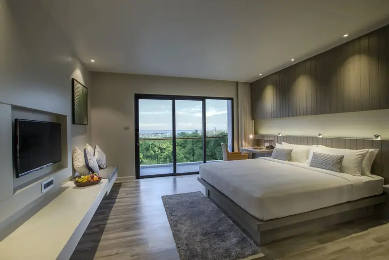 Une chambre lumineuse avec un grand lit et un accès à une vue dégagée.