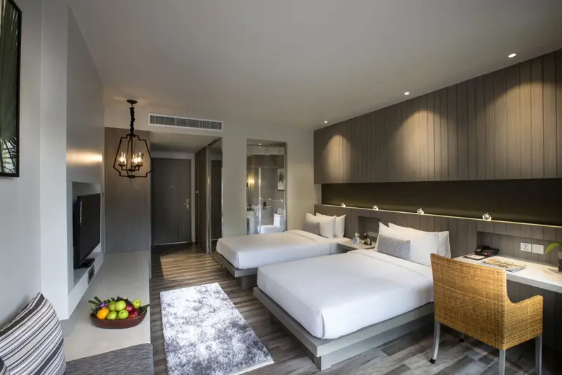 Une chambre lumineuse avec deux lits simples et un espace détente.