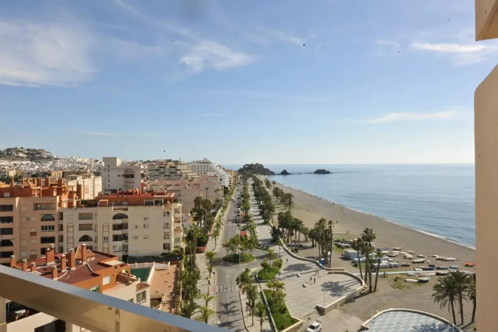 Vue aérienne sur une promenade en bord de mer et une plage de sable.