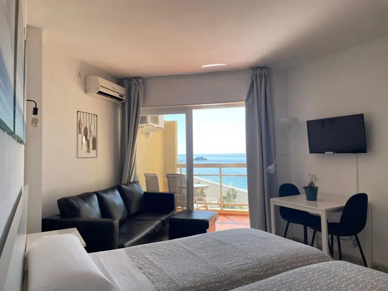 Une chambre lumineuse avec un canapé et une vue sur la mer.