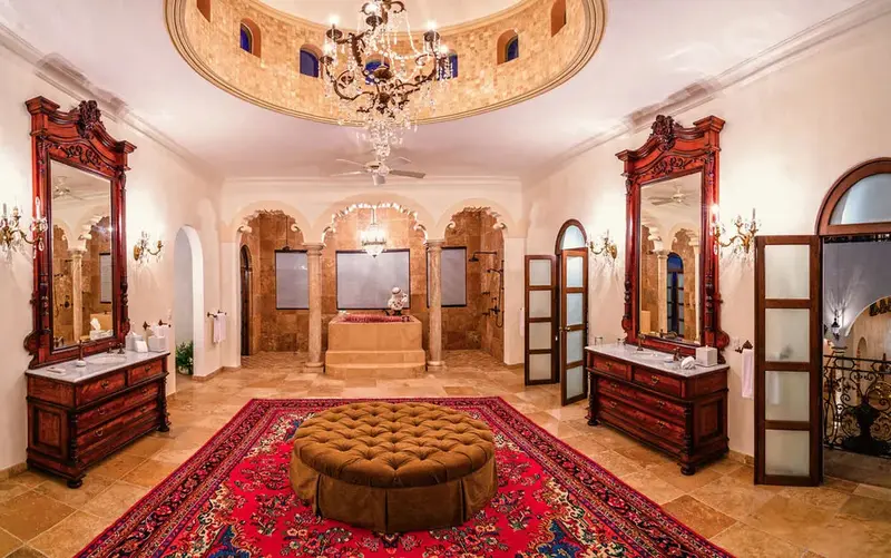 Une salle de bain spacieuse avec deux vasques et une baignoire centrale.