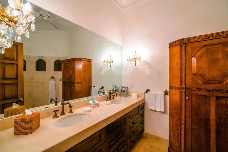 Une salle de bain lumineuse avec deux vasques et des armoires en bois.