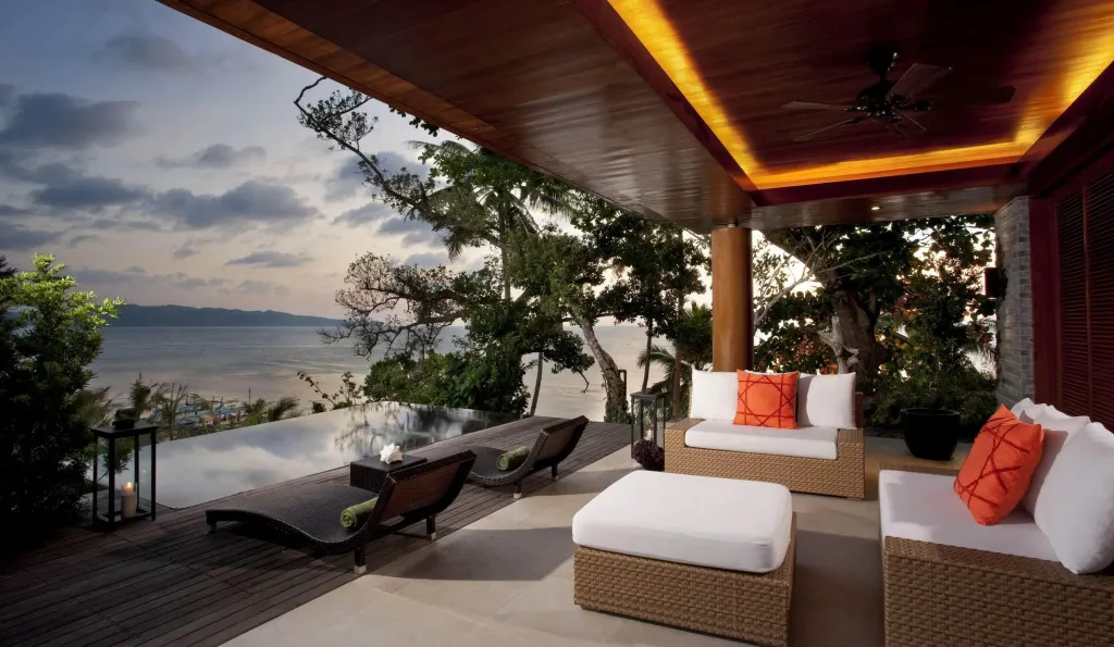 Espace de détente extérieur avec mobilier confortable et vue sur la mer.