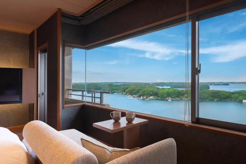 Vue sur une baie depuis un espace de détente intérieur.
