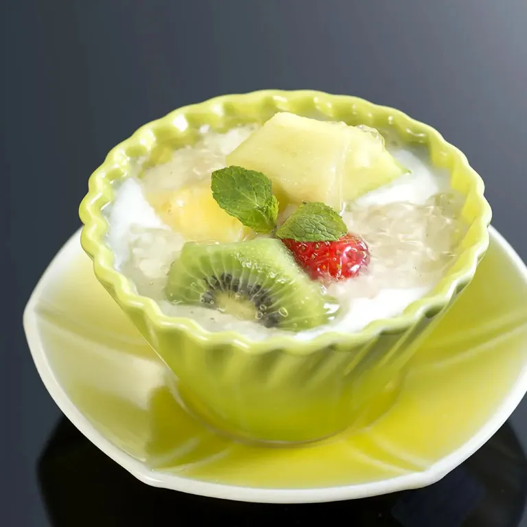 Un dessert à base de fruits frais et de lait de coco est présenté dans un bol en forme de fleur.